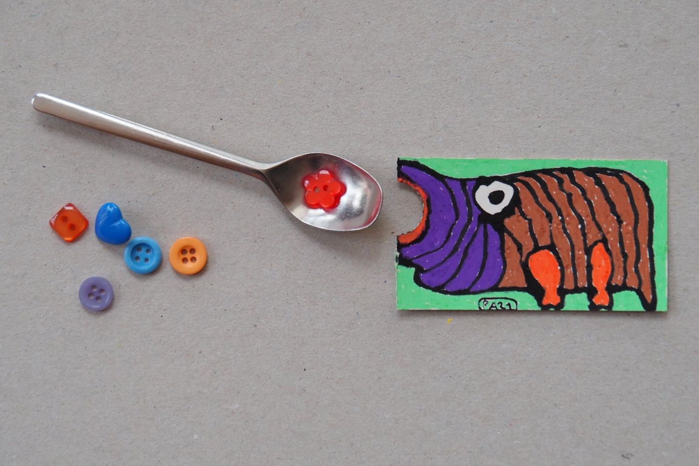 montage humoristique : dessin d'hippopotame gueule ouverte devant une petite cuillère contenant des perles de couleur en plastique