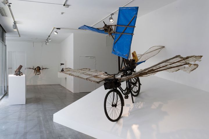 photo du vélo de l'artiste Gustav Mesmer avec des ailes bleues exposé à la maison rouge