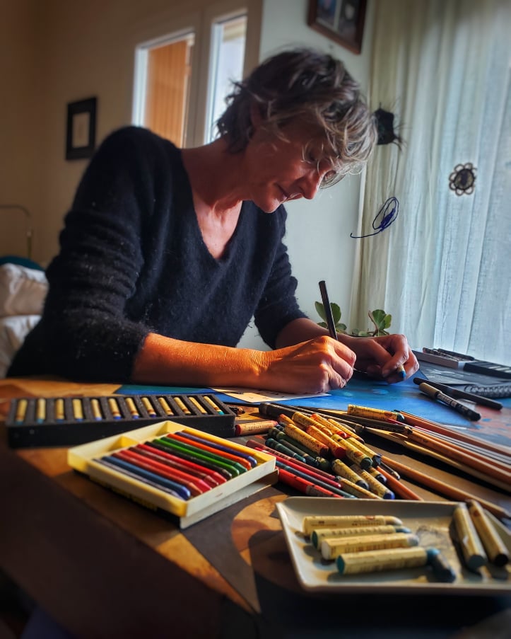 photographie couleur qui représente l'artiste Elisabeth Baldach à sa table de travail