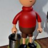 image qui représente un garçon en short et pull-over portant un seau réalisée en bois par Guy Pirot
