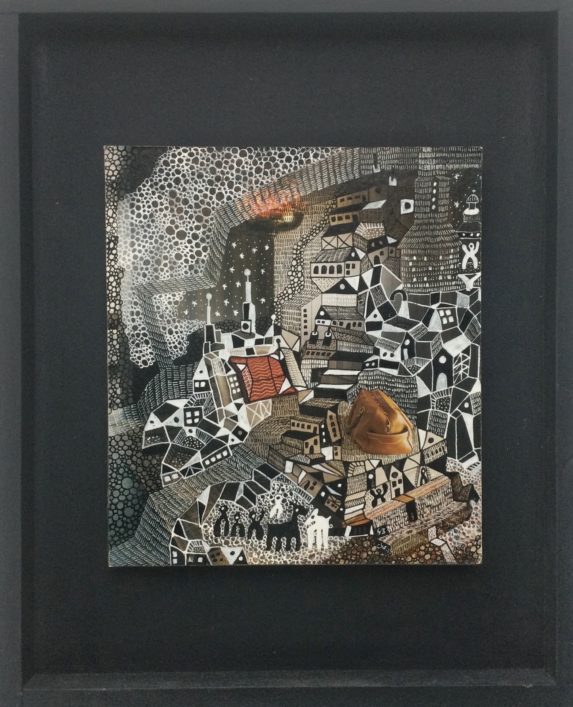 image d'un tableau de Christien de Jong réalisé à partir d'une page de magazine, dessin à l'encre de chine qui représente un village en espalier. Cadre caisse américaine noire