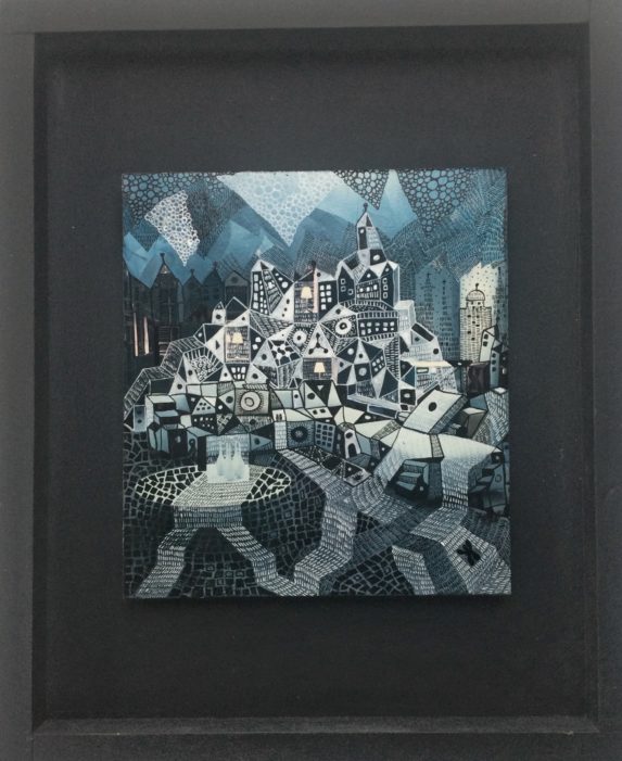 image d'un tableau de Christien de Jong réalisé à partir d'une page de magazine qui représente un village, dessin à l'encre de chine. Cadre caisse américaine noire