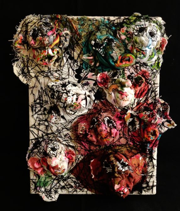Image de neuf visages en sculpture textile peints sur toile . Techniques mixtes.