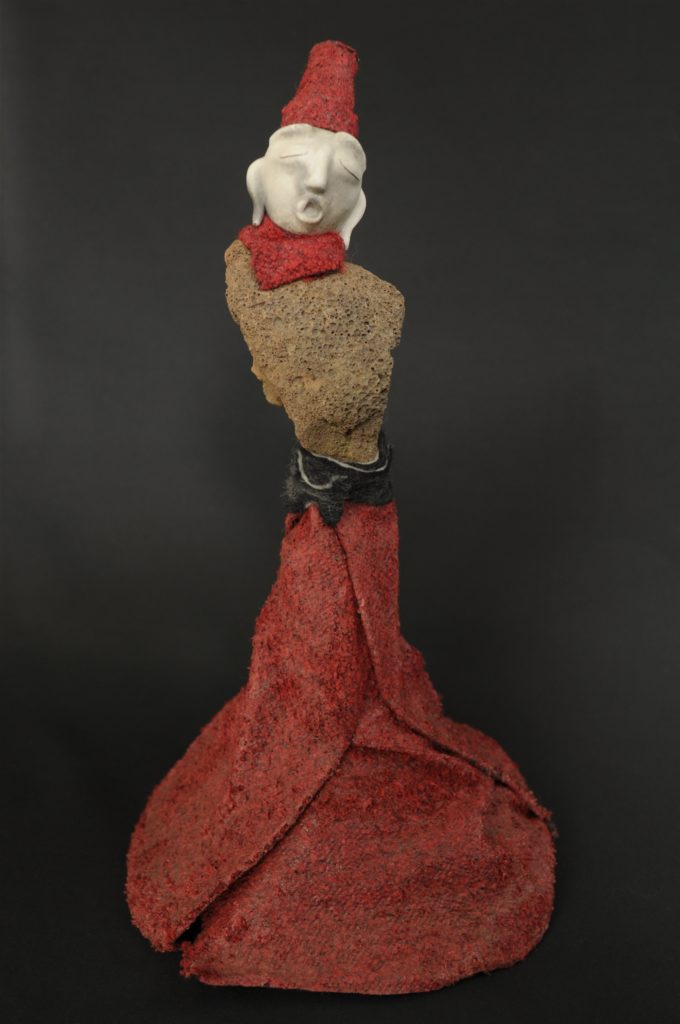 sculpture d'Elise Geoffrion Série " Semeurs de Rêves " H 45 / L 21 / P 21 cms Poids : 1 kg Grès blanc avec un four d'enfumage. Roche volcanique cueillie dans le Parc Naturel du Haut Languedoc. Laine feutrée et vernie.