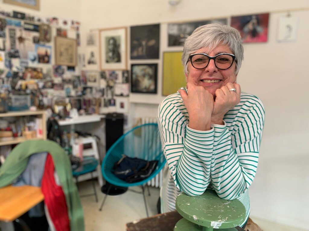 photographie qui représente la sculptrice Pascale Marchesini-Arnal dans son atelier accoudée sur un tour