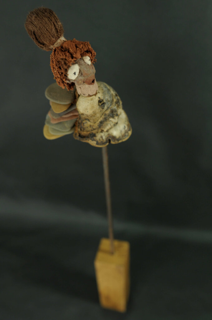 oeuvre d'Elise Geoffrion Techniques : Papier mâché / Amadouvier / Textile / Terre / Galets polis et rejetés par la mer. Dimensions : H 39 / L 3,5 / P 5 cms Année de réalisation : 2023 Prix : 180€