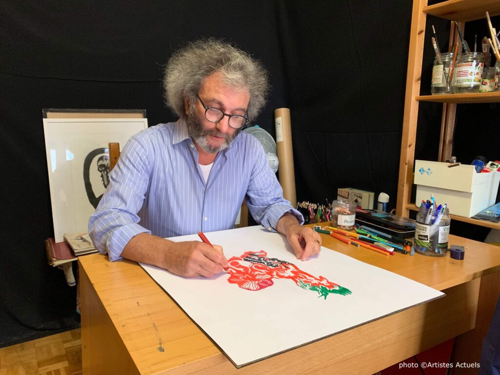 photographie de l'artiste José Guirao qui dessine à sa table de travail