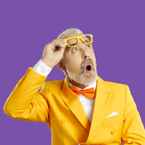 image qui représente un homme avec cheveux et barbe gris en costume jaune et noeud papillon orange que regarde de côté avec expression d'étonnement et qui relève de grosses lunettes jaunes